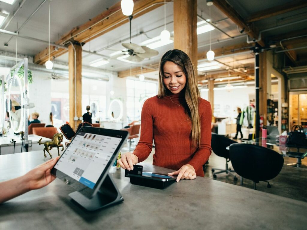 Shop owner taking a payment on a tablet